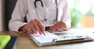 Profesyonel, masadaki panoda tıbbi taramaları ve raporları inceler. İş arkadaşlarıyla işbirliği, hastanede teşhis ve hasta bakımını vurguluyor