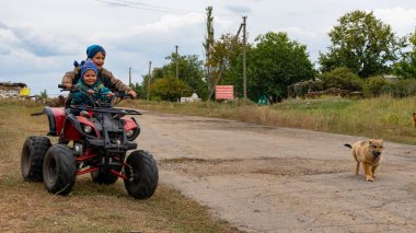 Donbass, Donetsk bölgesi/Ukrayna - 20 Eylül 2019: Doğu Ukrayna'nın Donbass kentinde fronline yakınlarında oynayan savaş çocukları. Mayın tarlasına yakın Luhanskoe köyünde ki kontrol noktasının yakınında oynayan çocuklar.  