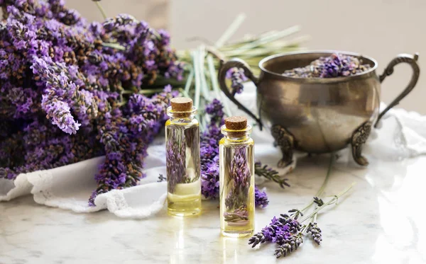 Botellas de aceite de lavanda, hierba natural cosmética consepto con flores de lavanda flatlay sobre fondo de piedra — Foto de Stock