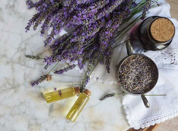 Lavendelölflaschen, natürliche Kräuterkosmetik mit Lavendelblüten flach auf Steinhintergrund — Stockfoto