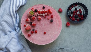 Vegan ham kek çilek, kaju krem, Hindistan cevizi yağı ve Hindistan cevizi sütü ve Bankası ile yapılan badem, tarihler ve kuru kayısı, yulaf gevreği, lyophilisated berry, üstten görünüm, taş gri arka plan