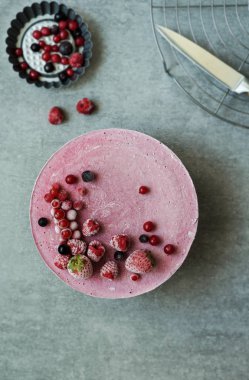 Vegan ham kek çilek, kaju krem, Hindistan cevizi yağı ve Hindistan cevizi sütü ve Bankası ile yapılan badem, tarihler ve kuru kayısı, yulaf gevreği, lyophilisated berry, üstten görünüm, taş gri arka plan