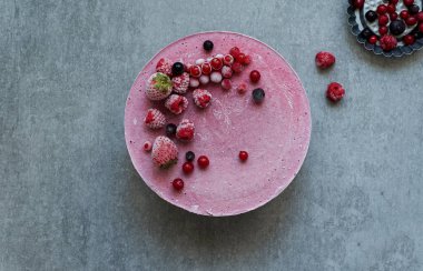 Vegan ham kek çilek, kaju krem, Hindistan cevizi yağı ve Hindistan cevizi sütü ve Bankası ile yapılan badem, tarihler ve kuru kayısı, yulaf gevreği, lyophilisated berry, üstten görünüm, taş gri arka plan