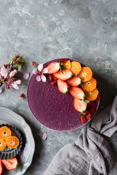 raw vegan cake with fruit and seeds, decorated with flowers