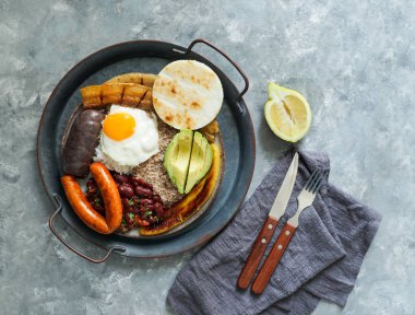 Kolombiya yemeği. Bandeja paisa, Kolombiya 'nın Antioquia bölgesinde tipik bir yemek. Kızarmış domuz göbeği, kara puding, sosis, arepa, fasulye, kızarmış muz, avokado yumurtası ve pirinç..