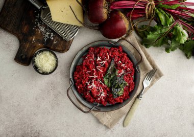 Sert peynirli pancar pilavı, karamelize yapraklar, koyu siyah arka plan.