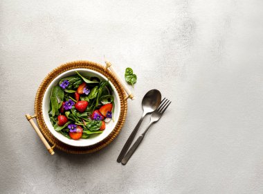 Taze yaz salatası ıspanak, çilek, soğan ve balzamik sirke ve yenilebilir çiçekler.;