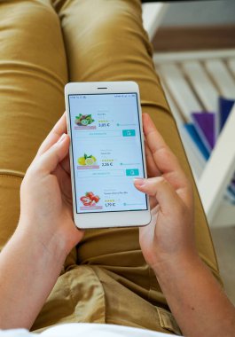 Mobil ev teslimatı, cep telefonu kadının elinde meyve seçiyor.