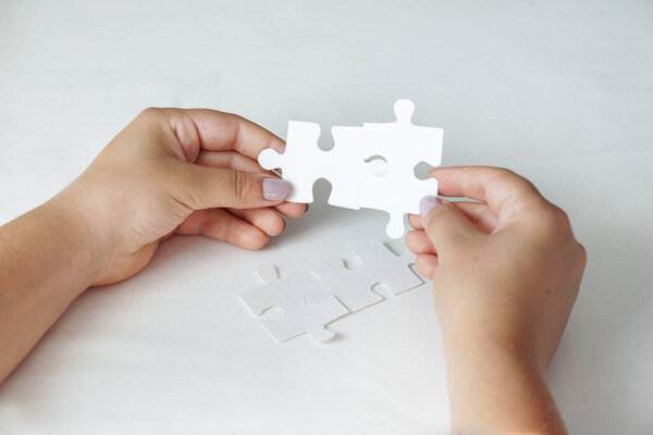 Concept of business, women hands holding white puzzle pieces