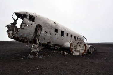 Vintage bir askeri uçak enkazı bir uzaktan siyah kum plaj üzerinde çöktü