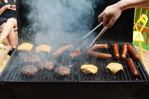 Hamburgers and Sausages On a Backyard Barbecue Grill