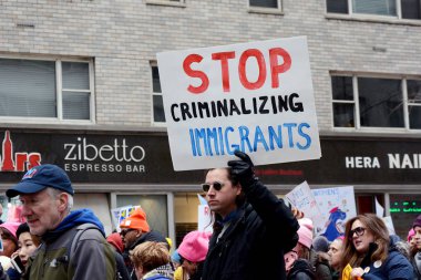 Midtown, Manhattan, New York'taki üzerinde 19 Ocak 2019 caddede 6 Mart'ta kadınların, göçmenler işareti suç durdurmak