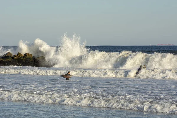 Deux Surfeurs Font Queue Avec Des Vagues Écrasant Contre Jetée — Photo