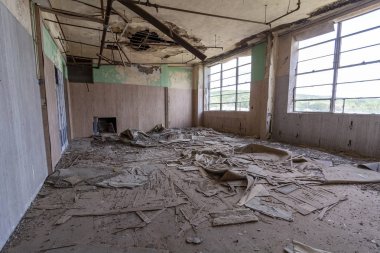 Terk edilmiş bir okul binasında enkazla dolu bir sınıf.