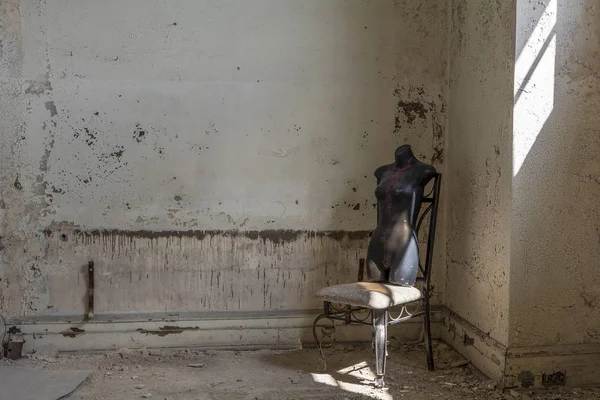 Stare Krzesło Czarnym Plastikowym Manekinem Torso Opuszczonym Budynku — Zdjęcie stockowe