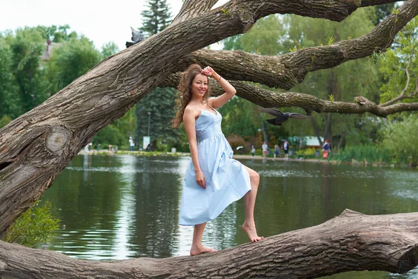 Красива Кучерява Дівчина Блакитній Сукні Стоїть Великому Дереві Фоні Парку — стокове фото