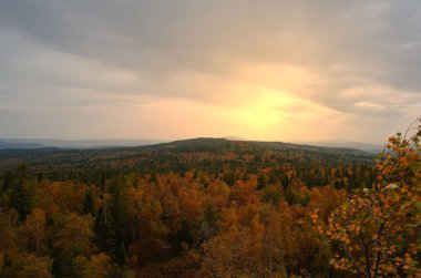 Sonbahar ormanındaki dağlarda gün batımı.