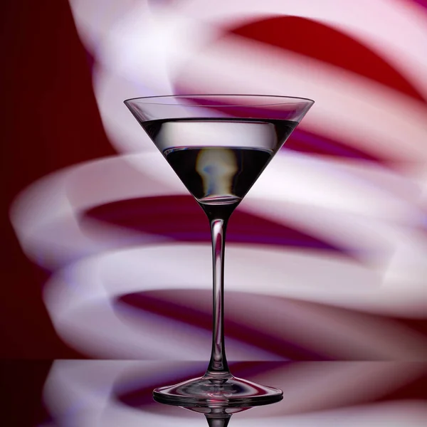 Martini-Glas auf rotem Hintergrund mit weißem Licht. — Stockfoto