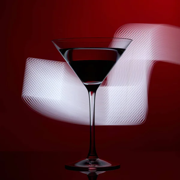 Martini-Glas auf rotem Hintergrund mit weißem Licht. — Stockfoto