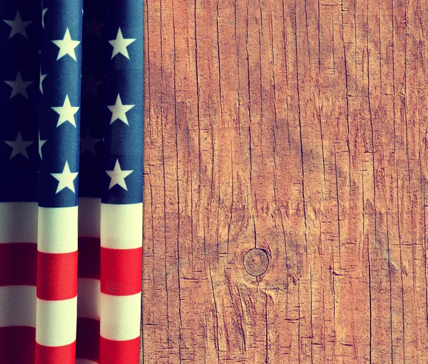 Overhead view of American flag on wooden background.