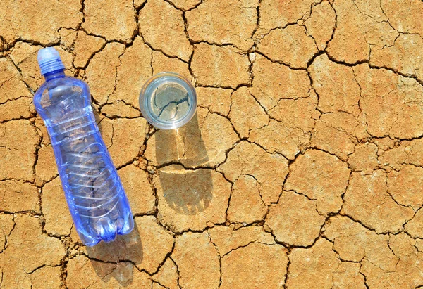 Flaska Och Glas Vatten Torr Sprucken Jord Begreppet Global Uppvärmning — Stockfoto
