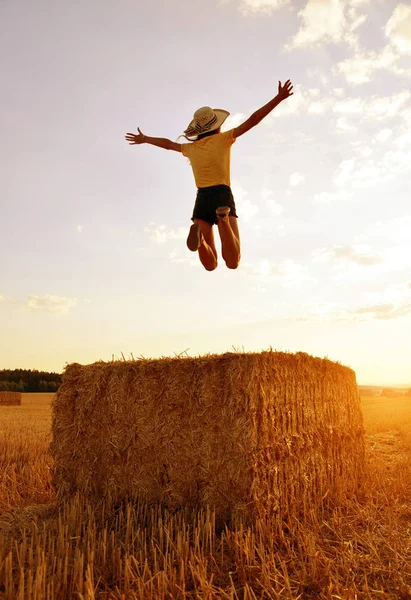 Chica Saltando Sobre Una Paca Paja Atardecer —  Fotos de Stock