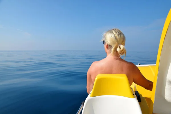 Woman on a pedal boat on water level in sunny day. Summer vacation by the sea.