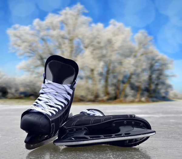 Black hockey skates on a ice rink.
