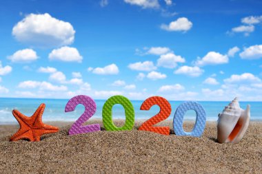 Sayı 2020 ve deniz kabuğu denizyıldızı kum plaj ile. Happy New Year ve yaz tatil kavramı.