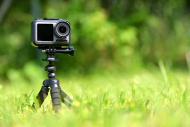 Chlumcany, Çek Cumhuriyeti - 09 Haziran 2019: Dji Osmo Action korumalı kasada ve çimde tripod.