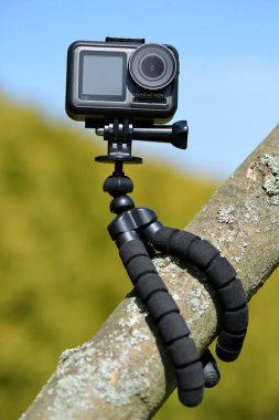 Chlumcany, Çek Cumhuriyeti - 09 Haziran 2019: Korunan kasada Dji Osmo Action ve ağacın dalında tripod.