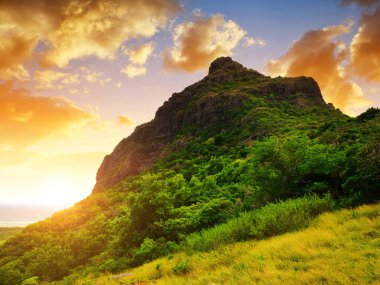 Mauritius adasının güneyindeki Le Morne Brabant Dağı. Günbatımında tropikal manzara.