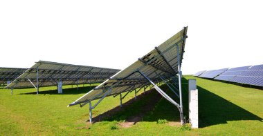 Çayırdaki güneş enerjisi panelleri. Sürdürülebilir kaynaklar. Beyaz arkaplanda fotovoltaik güç istasyonu.
