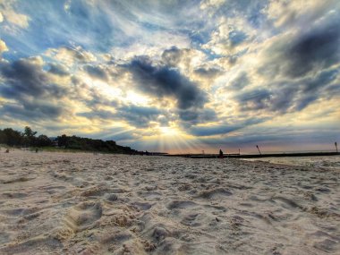 Baltık Denizi'nde gün batımı. Tehditkar bulutlar ve güzel güneş ışınları görebilirsiniz plaj yürüyüşü sırasında büyülü anlar.