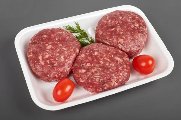Hamburguesas de carne en paquete de plástico aislado sobre fondo blanco — Foto de Stock