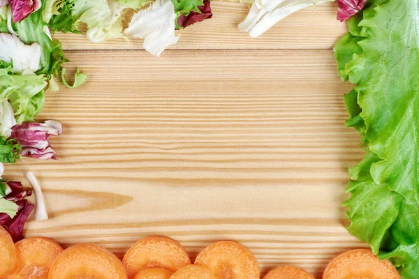 Frame of fresh vegetables on wooden background. Healthy natural food on table with copy space . Cooking ingredients top view, mockup for recipe or menu.