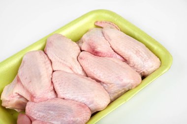 Beyaz arka plan üzerinde izole çiğ tavuk kanatları paketi