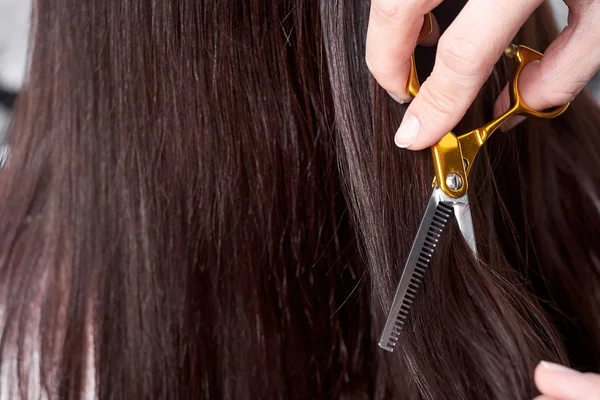 Primer plano de una peluquera cortando el pelo de una mujer . — Foto de Stock