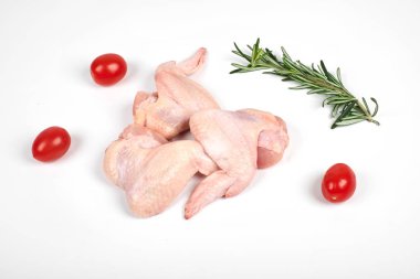 Çiğ tavuk kanatları, domates ve beyaz arka plan üzerinde izole biberiye