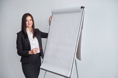 flipchart Office tarafından duran genç gülümseyen iş kadını portresi