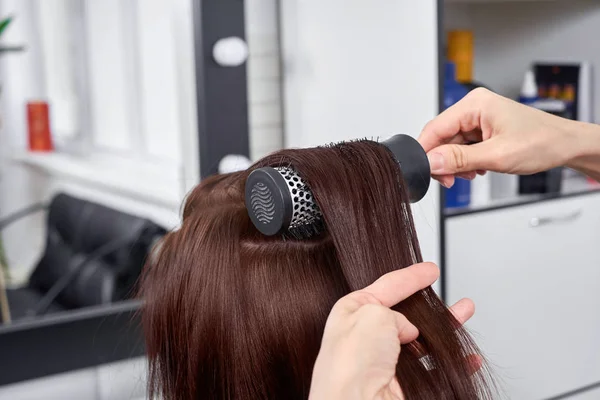 Primo piano parrucchiere fa acconciatura per giovane donna nel salone di bellezza — Foto Stock