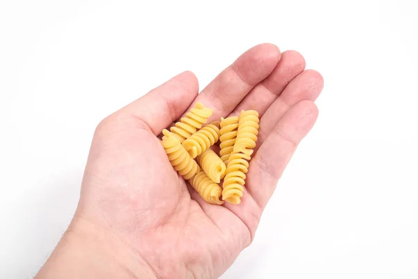 Fusilli pasta nudlar i en hand, isolerad på en vit bakgrund — Stockfoto