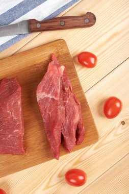 Çiğ et parçası ve ahşap kesme tahtası dilimleri