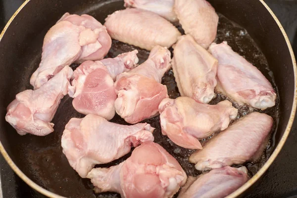 Asas de frango fritas na panela com óleo quente, comida caseira — Fotografia de Stock