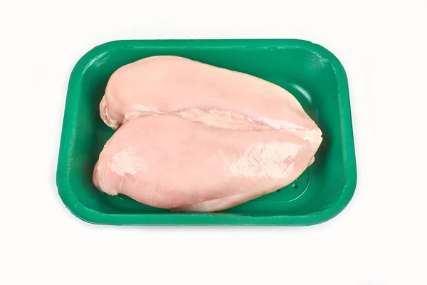 Pechuga de pollo cruda en una bandeja sobre un fondo blanco . — Foto de Stock