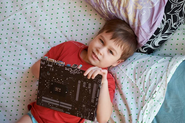 Kleine jongen speelt met een circuit bord. — Stockfoto