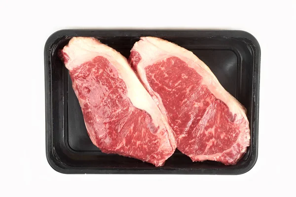 흰색 배경에 고립 된 쟁반에서 원시 쇠고기 스테이크. — 스톡 사진