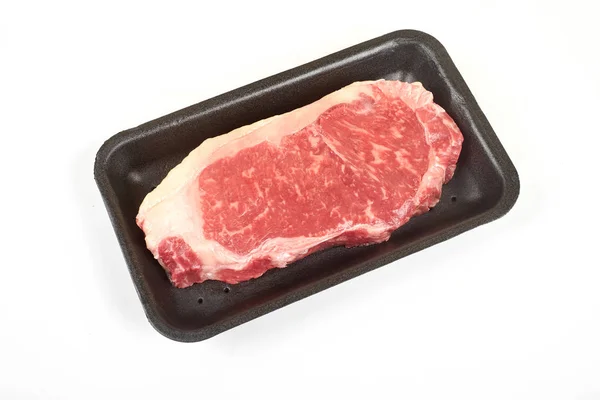 Nyers marha steak egy tálca, elszigetelt fehér background. — Stock Fotó