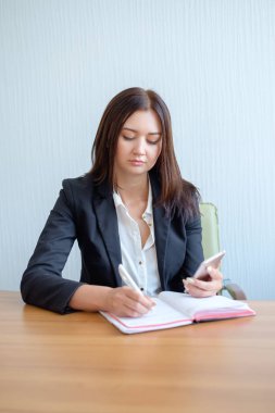 Notlar yapacak meşgul kadın ofis çalışanı