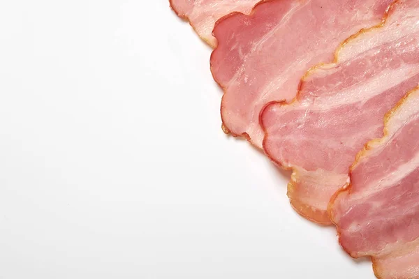Skivade fläsk bacon på en vit bakgrund, kopiera utrymme — Stockfoto